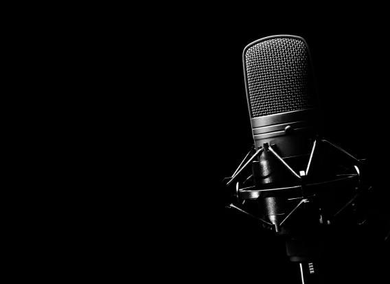 Close-up of a microphone with a solid black background.